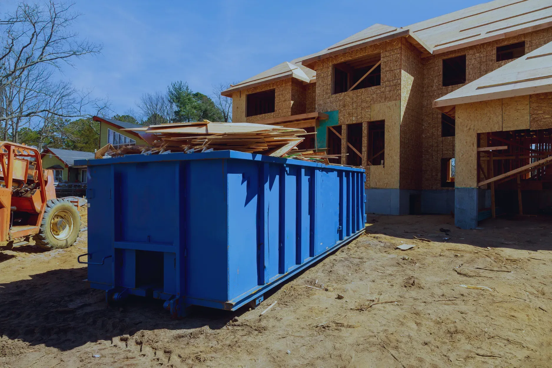 Blue dumpster at a residential construction site